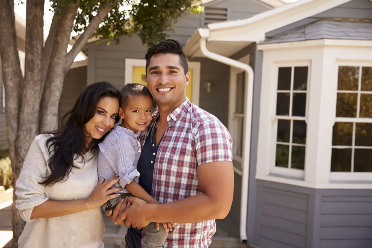 A hispanic family standing in front of their home. A hispanic family standing in front of their home.