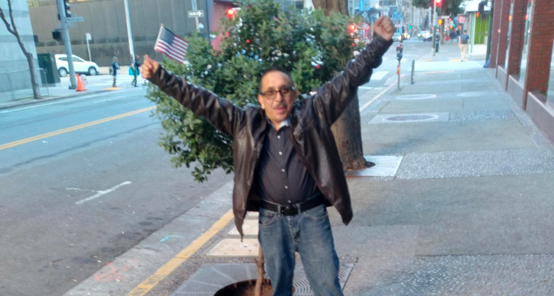 Ronald Cermeno, with his hands in the air standing on a sidewalk